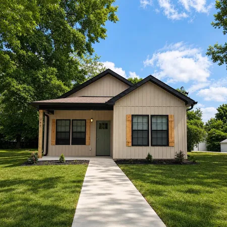 a front view of a house with a yard and trees