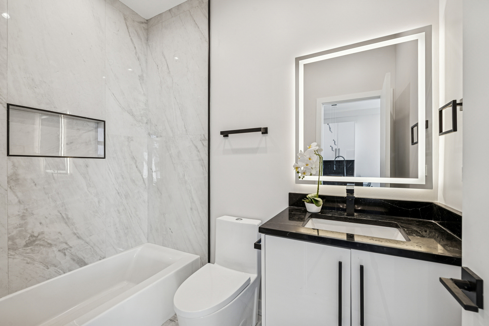 1355 North Western Avenue, Unit 2B Chicago, IL 60622 - Photo 12 of 16 a bathroom with a double vanity sink and mirror with bathtub