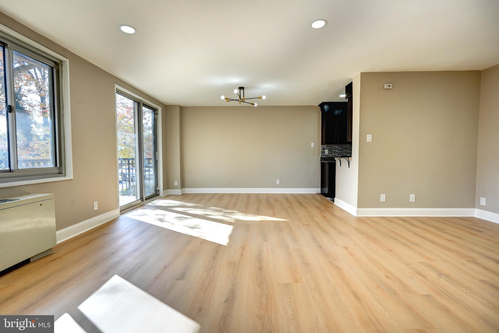 1900 Lyttonsville Road, Unit 211 Silver Spring, MD 20910 - Photo 3 of 46 an empty room with wooden floor and windows