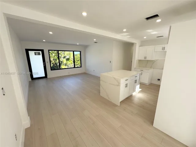 a view of empty room with wooden floor and window