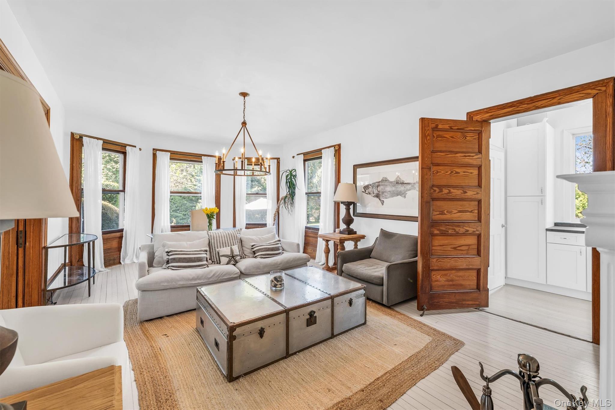 64 South Howells Point Road Bellport, NY 11713 - Photo 13 of 42 a living room with furniture and a chandelier