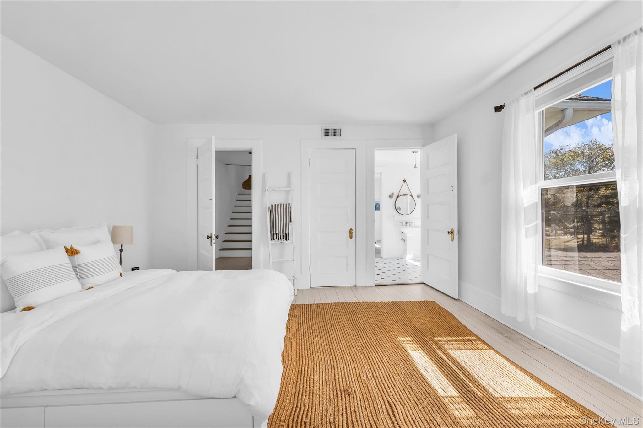 64 South Howells Point Road Bellport, NY 11713 - Photo 27 of 42 a spacious bedroom with a bed and a window