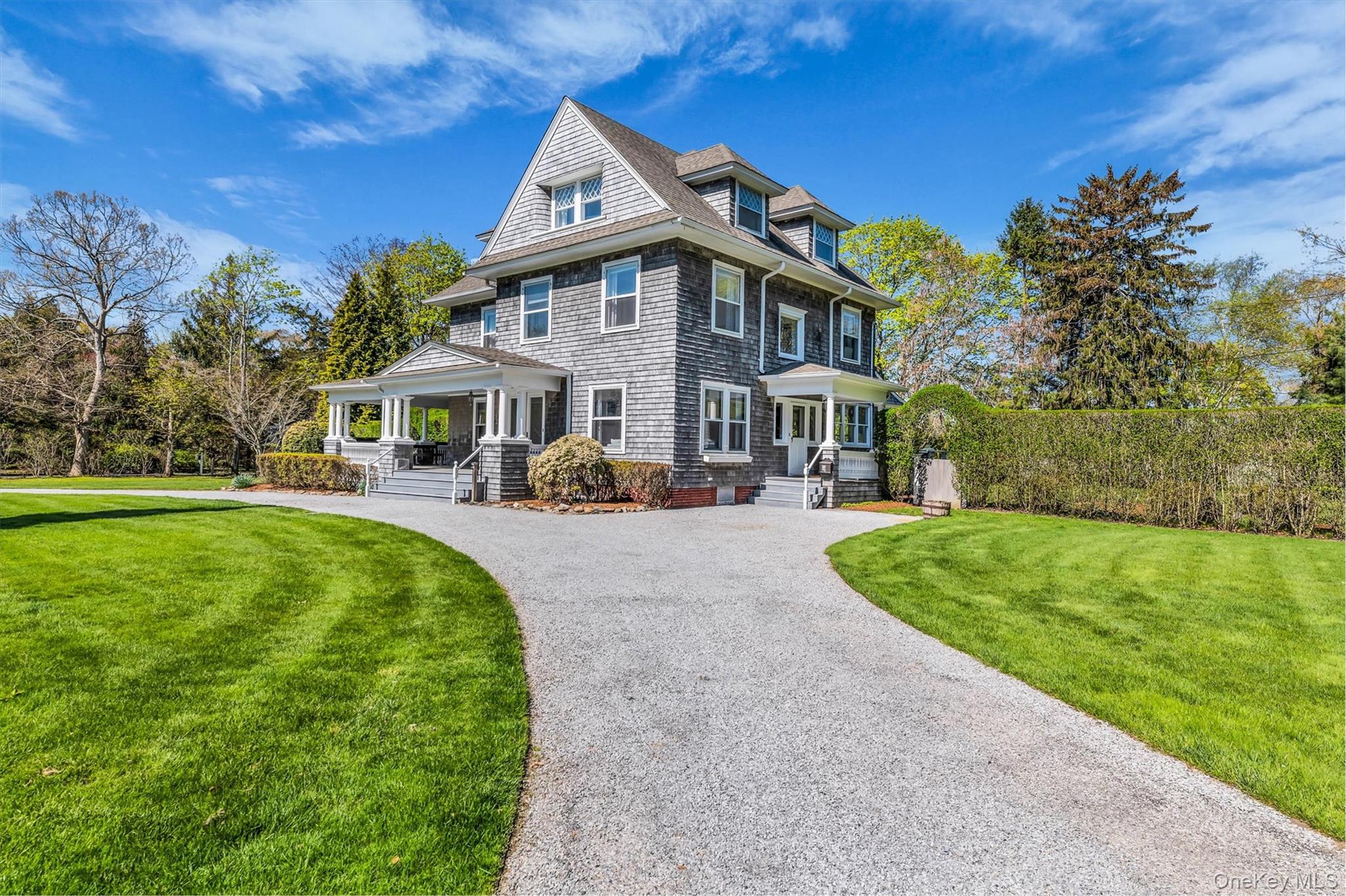 64 South Howells Point Road Bellport, NY 11713 - Photo 3 of 42 a front view of a house with a yard table and chairs