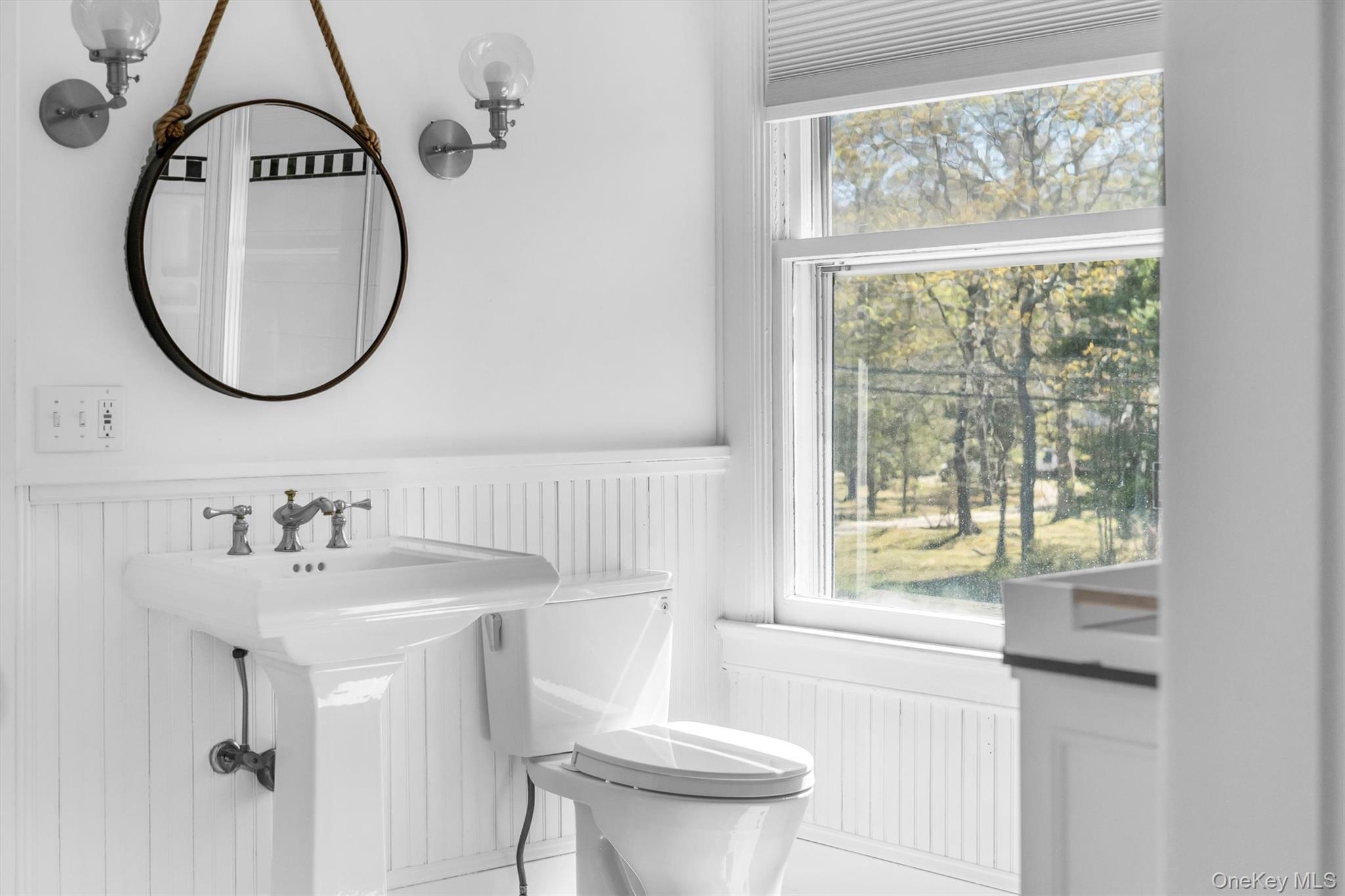 64 South Howells Point Road Bellport, NY 11713 - Photo 32 of 42 a bathroom with a sink a toilet and a mirror