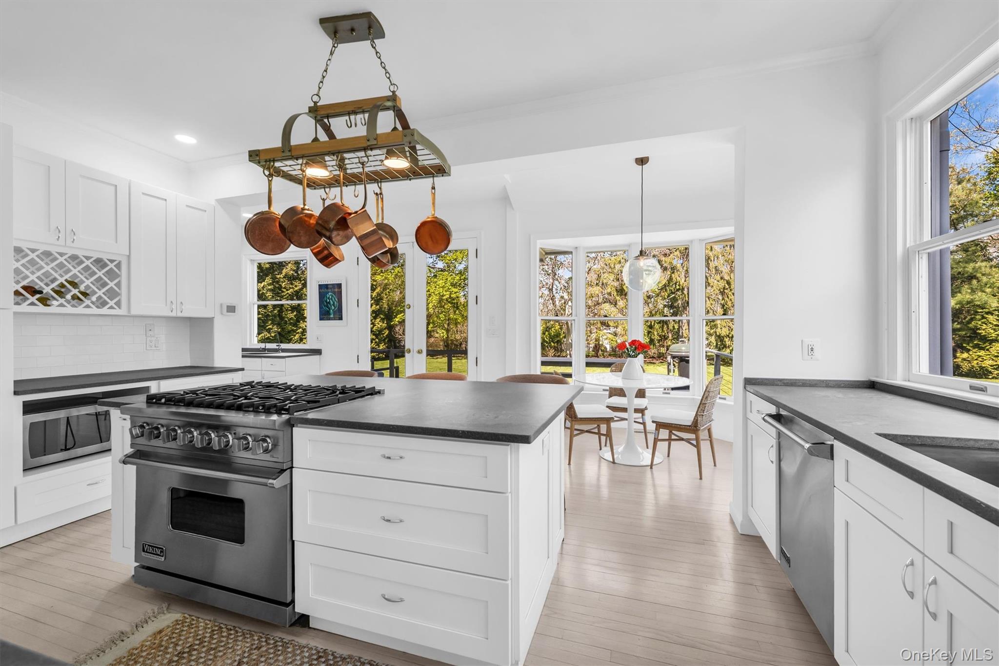 64 South Howells Point Road Bellport, NY 11713 - Photo 9 of 42 a kitchen with stainless steel appliances granite countertop a stove a chimney a sink and a wooden floor