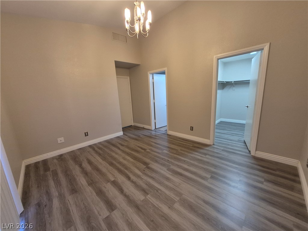 2053 Quarry Ridge Street, Unit 201 Las Vegas, NV 89117 - Photo 9 of 21 Vaulted ceilings elevate this well-lit room, featuring durable wood-look flooring and easy access to a convenient walk-in closet.