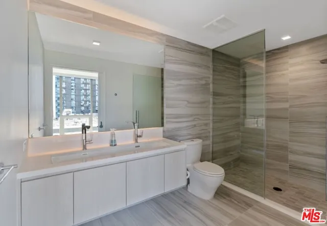a bathroom with a double vanity sink toilet and shower