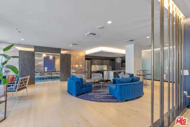 a living room with furniture a large window and chandelier