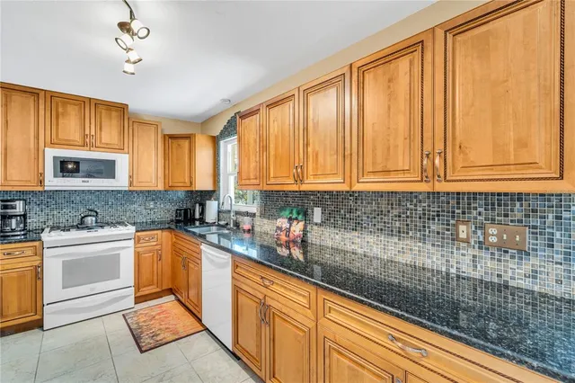 a kitchen with stainless steel appliances granite countertop a sink stove and cabinets