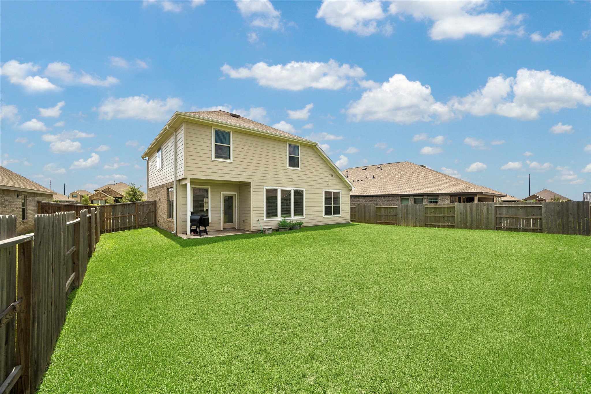 3812 Moss Hl Road Rosenberg, TX 77469 - Photo 5 of 20 Spacious two-story home with a large, well-maintained backyard, perfect for outdoor activities. The yard is enclosed by a wooden fence for privacy, and the house features a cozy patio area. Ideal for families or entertaining guests.