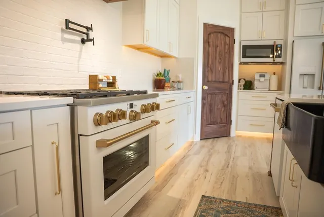 a kitchen with white cabinets and appliances