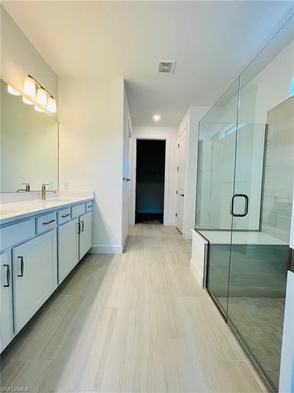 1962 Tripletail Lane Naples, FL 34114 - Photo 20 of 39 a large bathroom with a double vanity sink and mirror