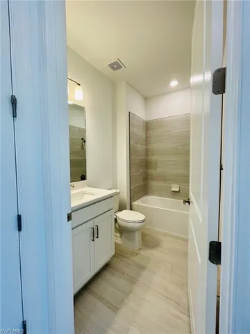 a bathroom with a granite countertop toilet a sink and shower