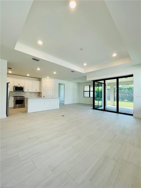 1962 Tripletail Lane Naples, FL 34114 - Photo 6 of 39 a view of an empty room with a kitchen and a window