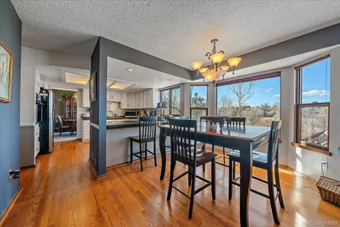 a dining room with furniture a chandelier and wooden floor