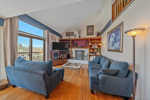 a living room with fireplace furniture and a large window