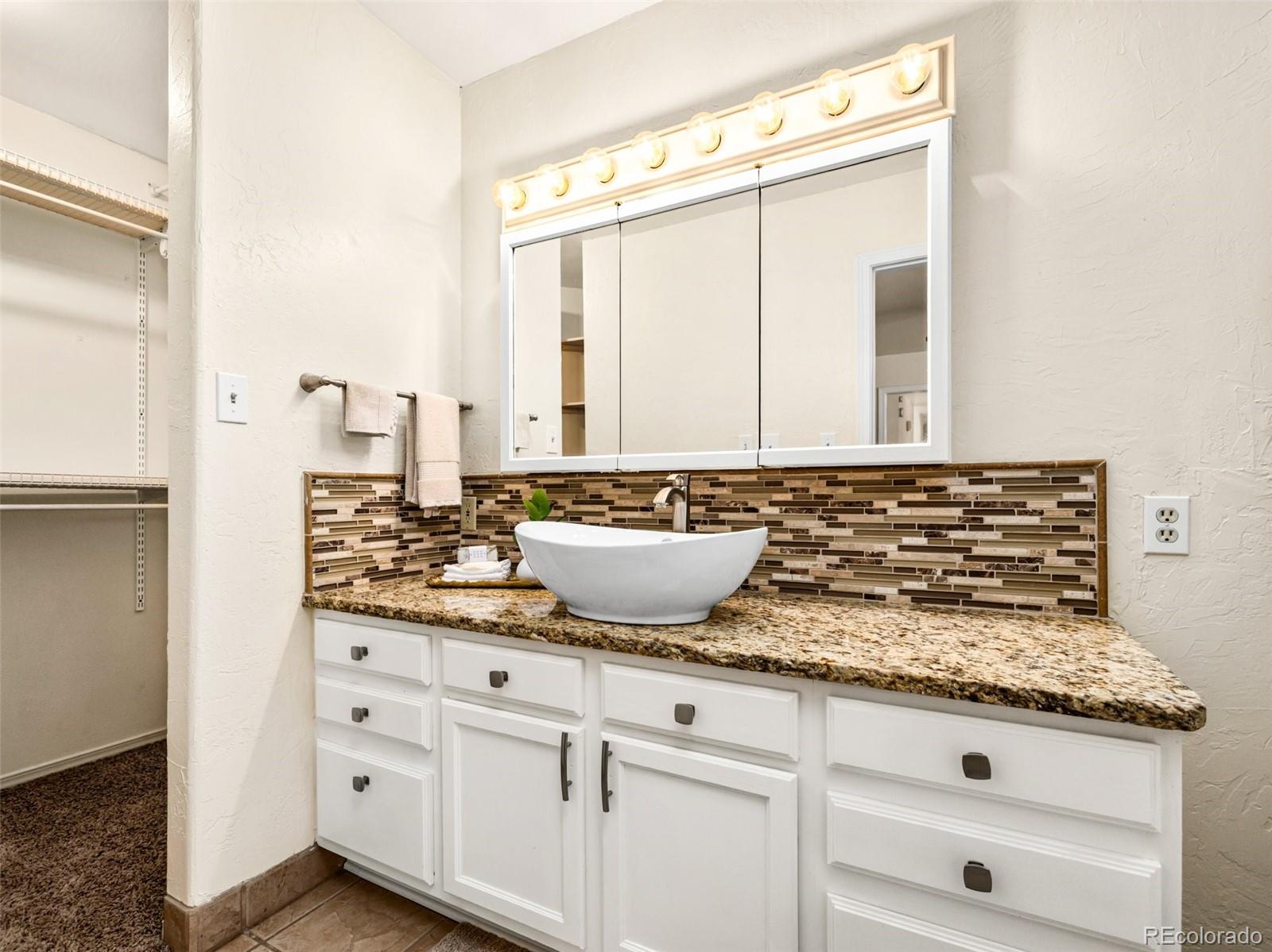 919 South Main Street Fowler, CO 81039 - Photo 21 of 36 a bathroom with a granite countertop sink and a mirror