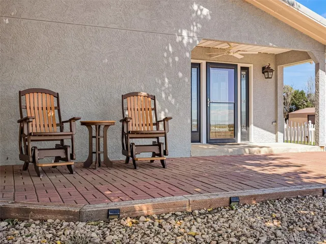 a view of a balcony with chairs and wooden floor