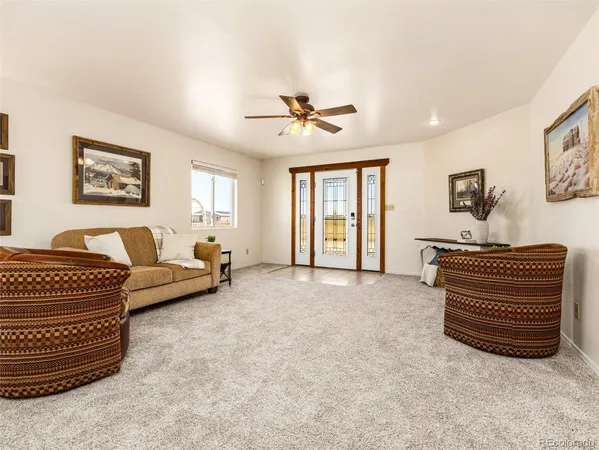 a living room with furniture and a ceiling fan