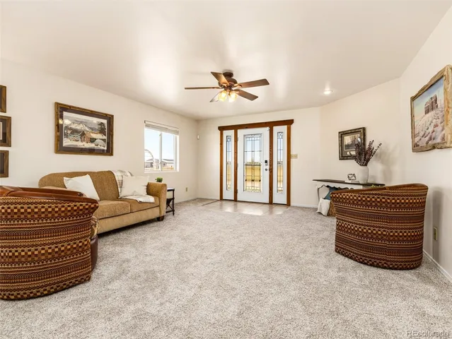 a living room with furniture and a ceiling fan