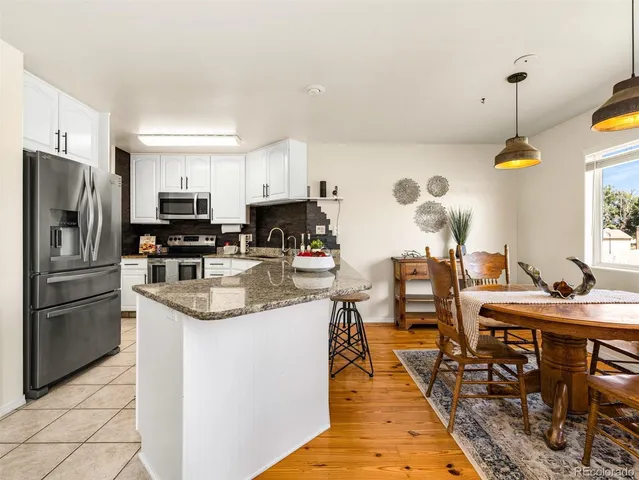 a kitchen with stainless steel appliances granite countertop a sink a stove and a refrigerator