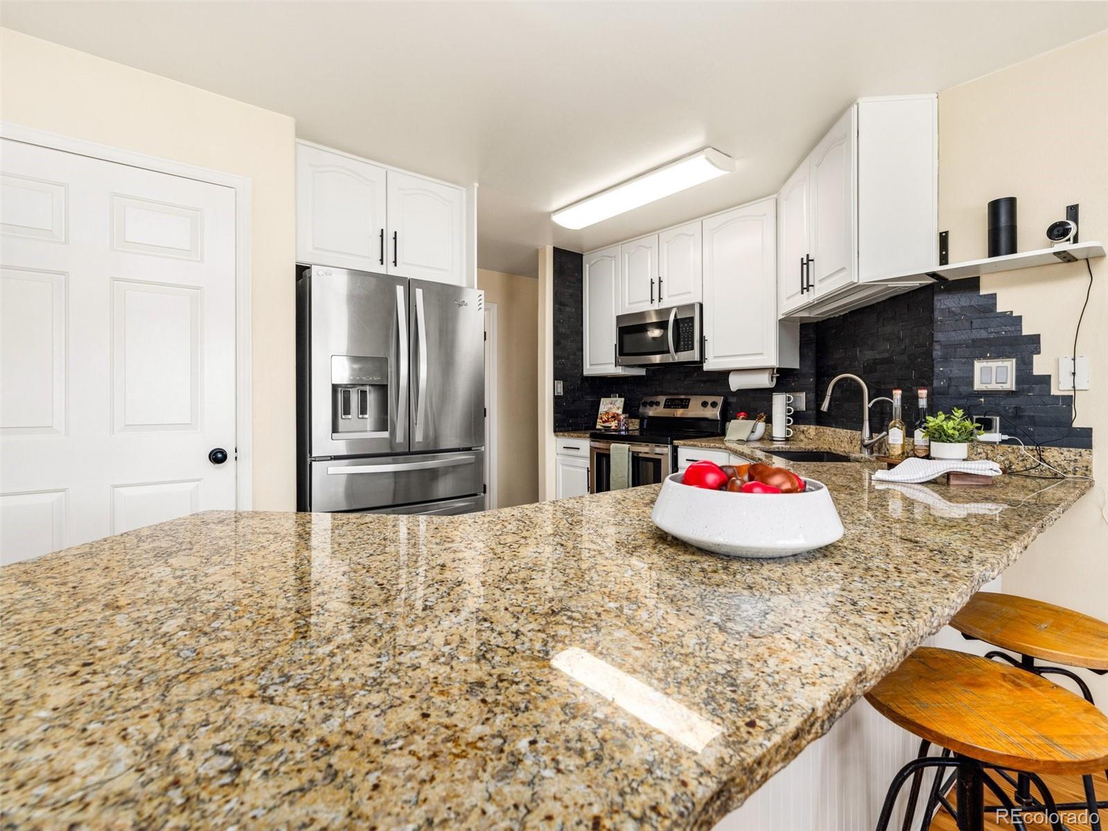 919 South Main Street Fowler, CO 81039 - Photo 8 of 36 a kitchen with stainless steel appliances kitchen island granite countertop a stove and cabinets