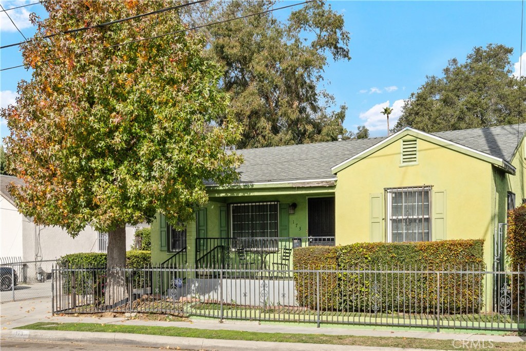 a view of a house with a yard and large tree