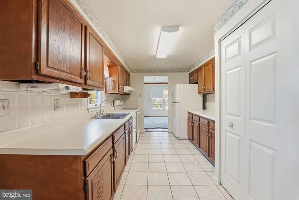 a kitchen with granite countertop a sink stove and cabinets