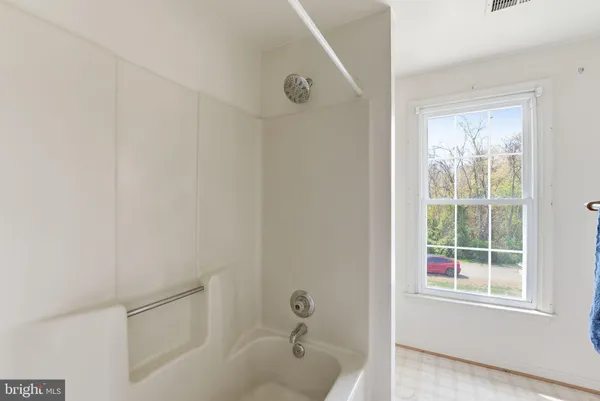 a bathroom with a tub sink vanity and mirror