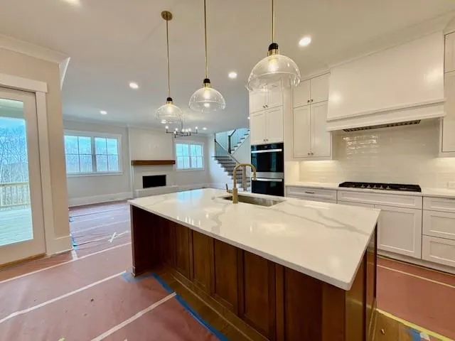 a large kitchen with kitchen island a stove a sink a center island and wooden floor