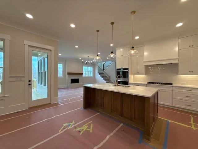 a large kitchen with kitchen island a sink stainless steel appliances and cabinets