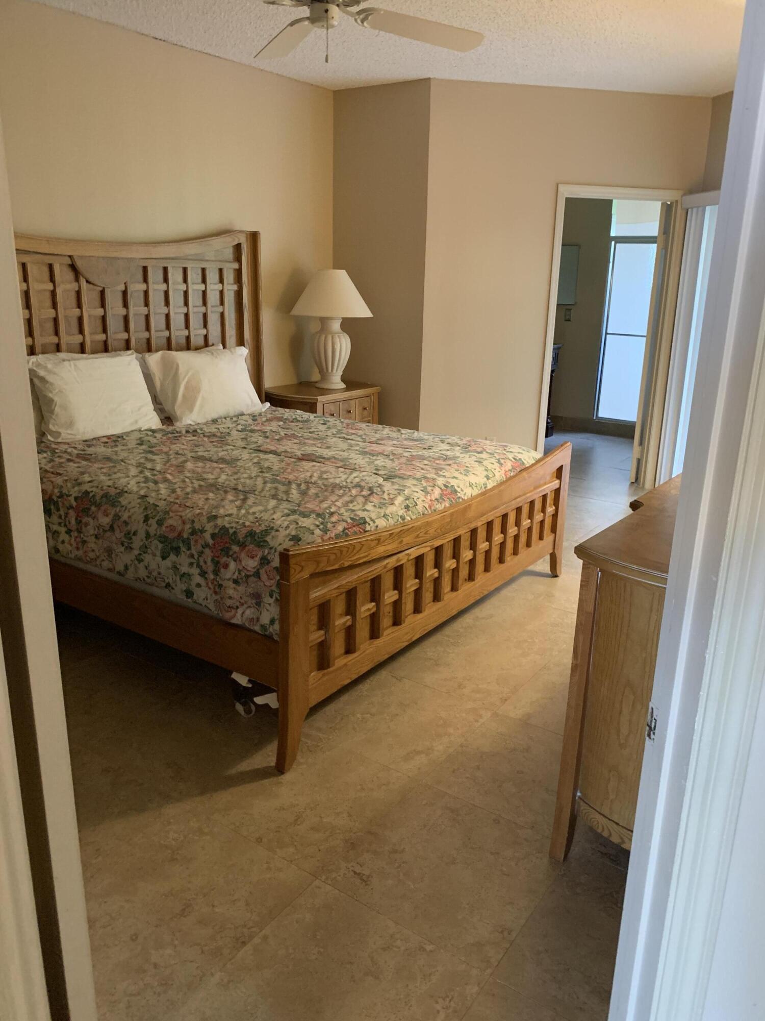 6674 Montego Bay Boulevard, Unit E Boca Raton, FL 33433 - Photo 11 of 18 a bed sitting in a bedroom next to a window