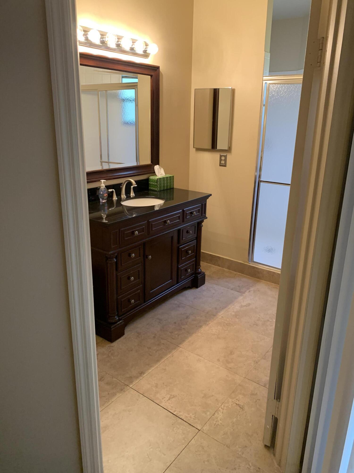 6674 Montego Bay Boulevard, Unit E Boca Raton, FL 33433 - Photo 13 of 18 a room with black cabinets and wooden floor