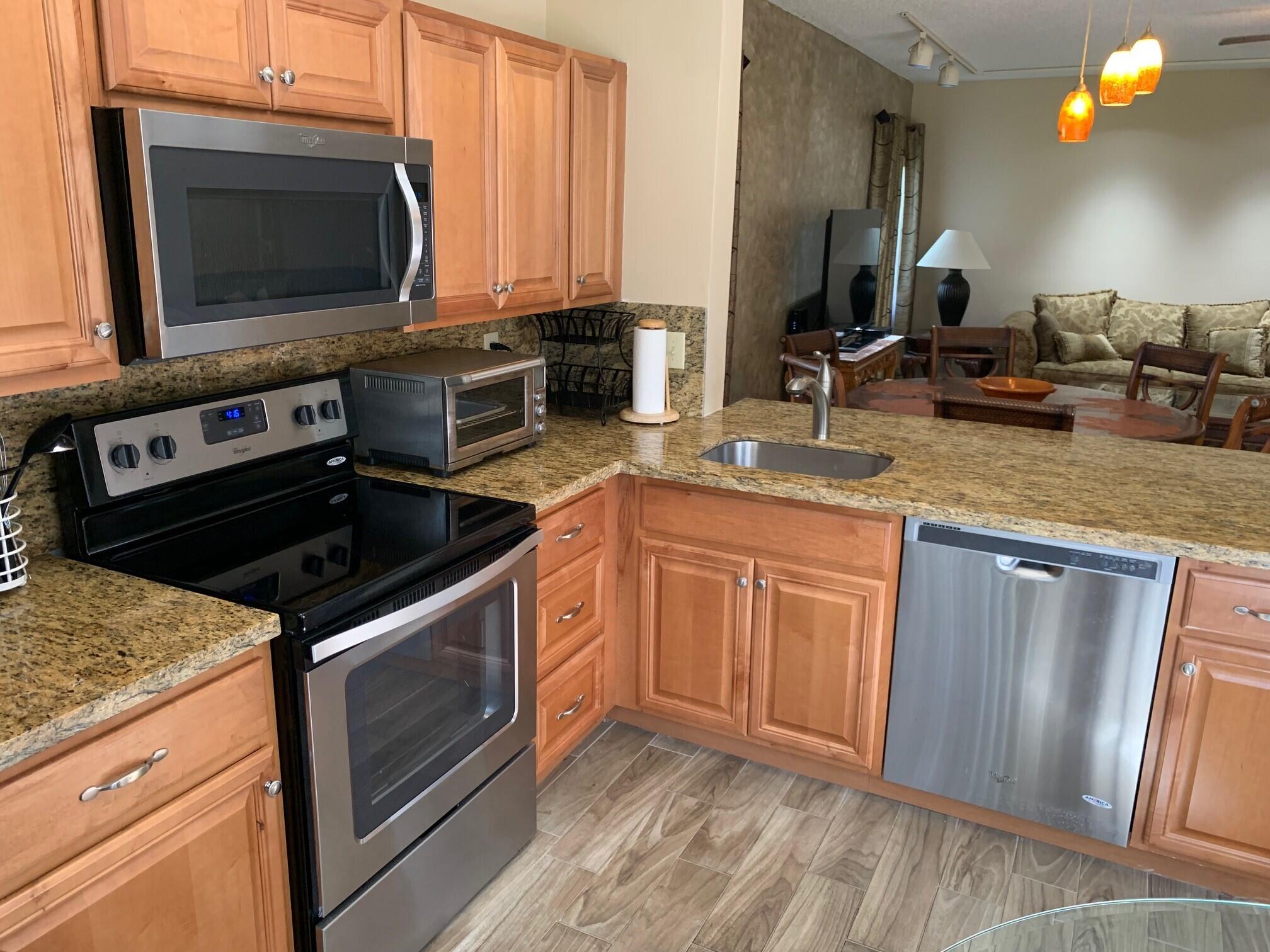 6674 Montego Bay Boulevard, Unit E Boca Raton, FL 33433 - Photo 3 of 18 a kitchen with granite countertop a stove sink and microwave