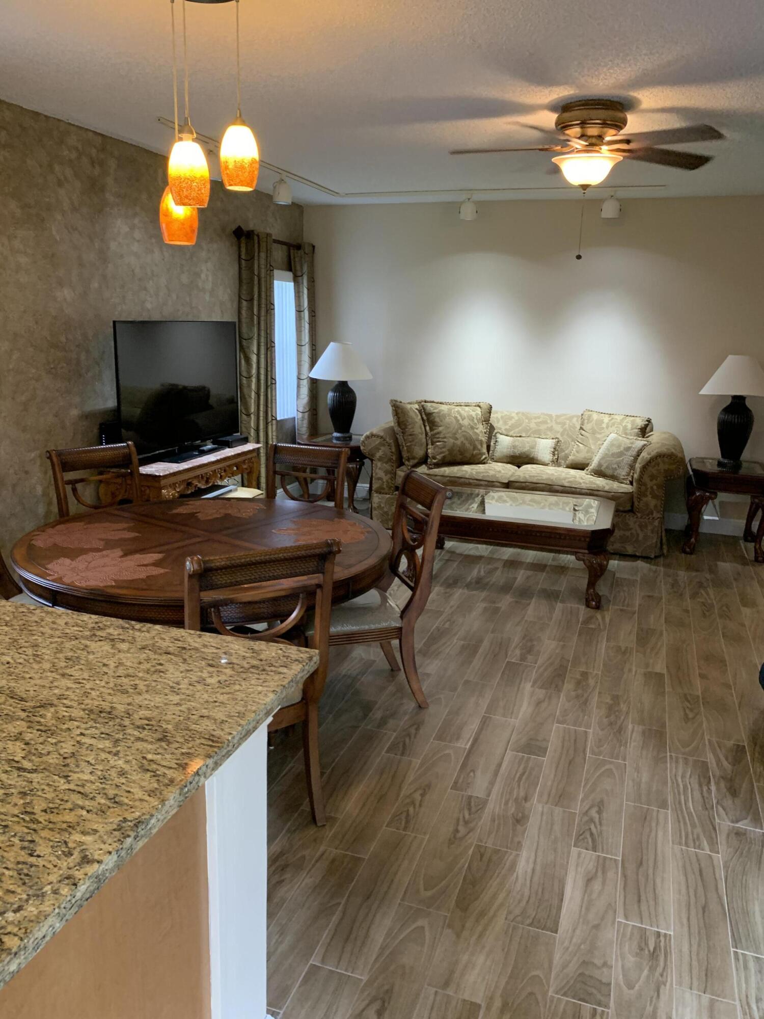 6674 Montego Bay Boulevard, Unit E Boca Raton, FL 33433 - Photo 6 of 18 a living room with furniture and a flat screen tv