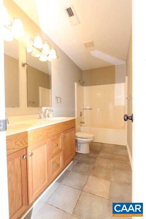 60 Geranium Road Ruckersville, VA 22968 - Photo 17 of 21 a bathroom with a double vanity sink a toilet and a mirror