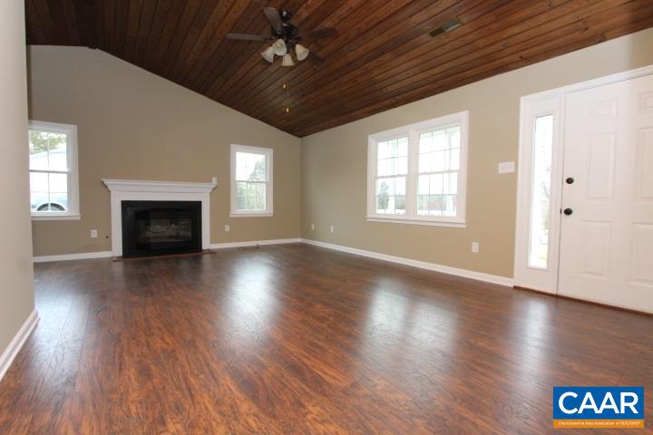 60 Geranium Road Ruckersville, VA 22968 - Photo 10 of 21 an empty room with wooden floor fireplace and windows