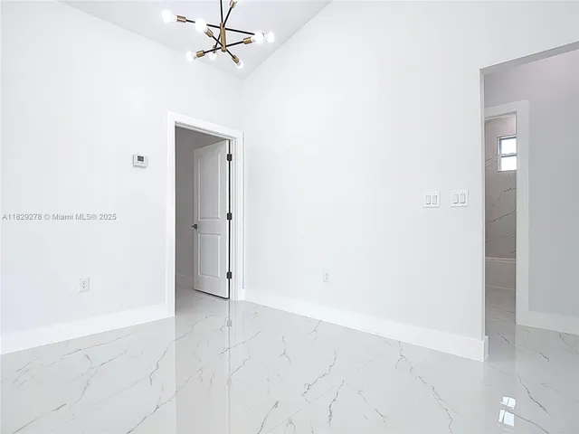 an empty room with a ceiling fan and carpet