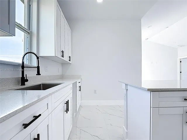 a kitchen with white cabinets and a sink