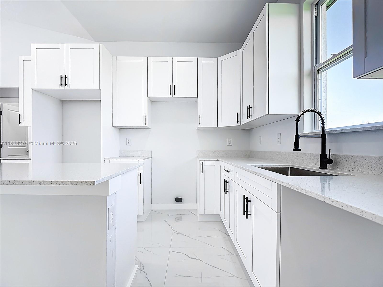 5002 Bygone Street Lehigh Acres, FL 33971 - Photo 21 of 51 a kitchen with a sink stove and cabinets