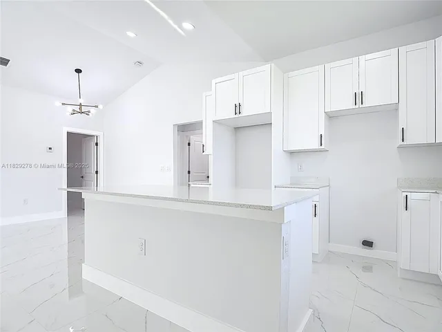 a kitchen with cabinets appliances a sink and a counter top space