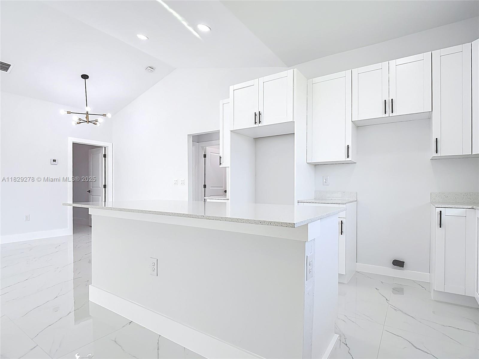 5002 Bygone Street Lehigh Acres, FL 33971 - Photo 22 of 51 a kitchen with stainless steel appliances a refrigerator and cabinets