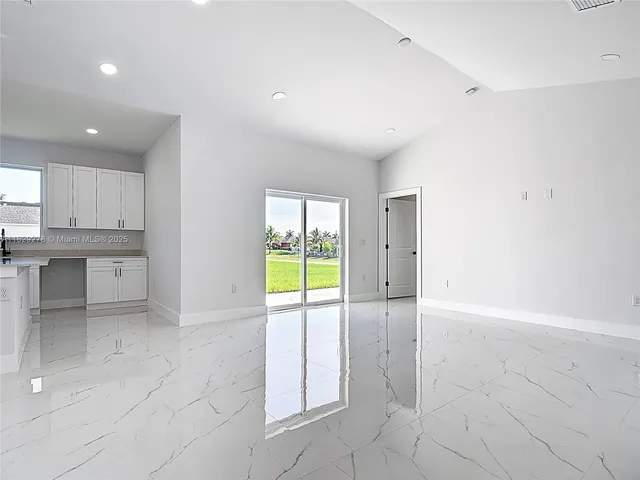 a view of a kitchen with kitchen island and windows