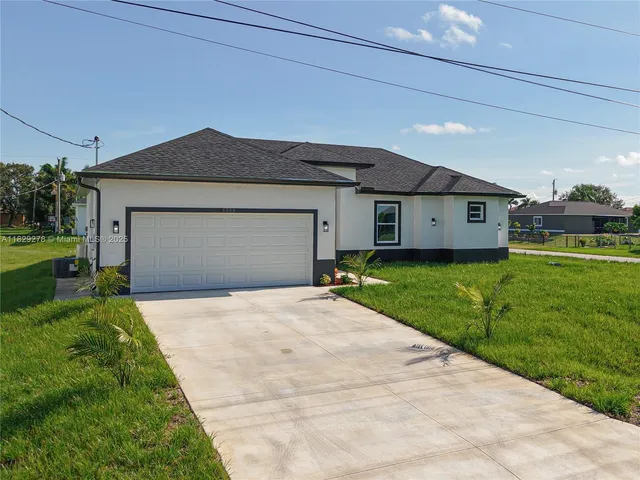 a front view of a house with a yard and garage