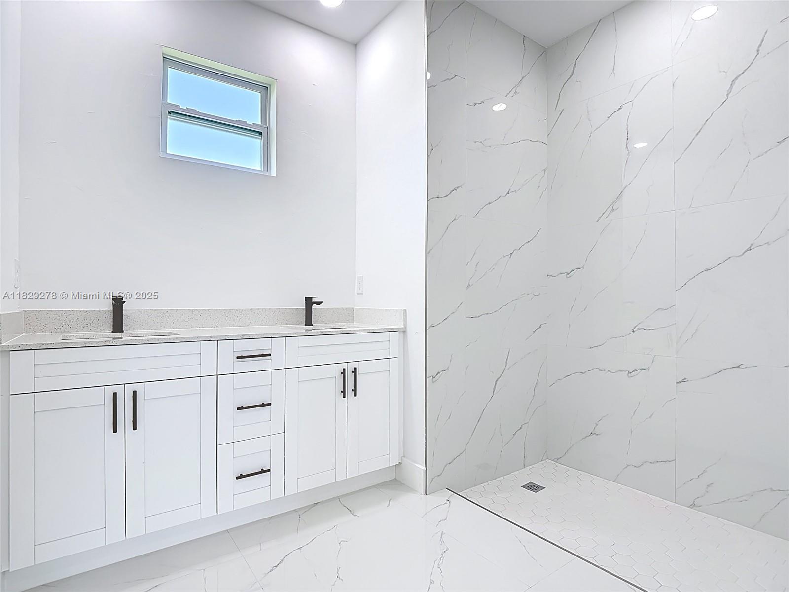 5002 Bygone Street Lehigh Acres, FL 33971 - Photo 36 of 51 a bathroom with 2 sink and a bathtub