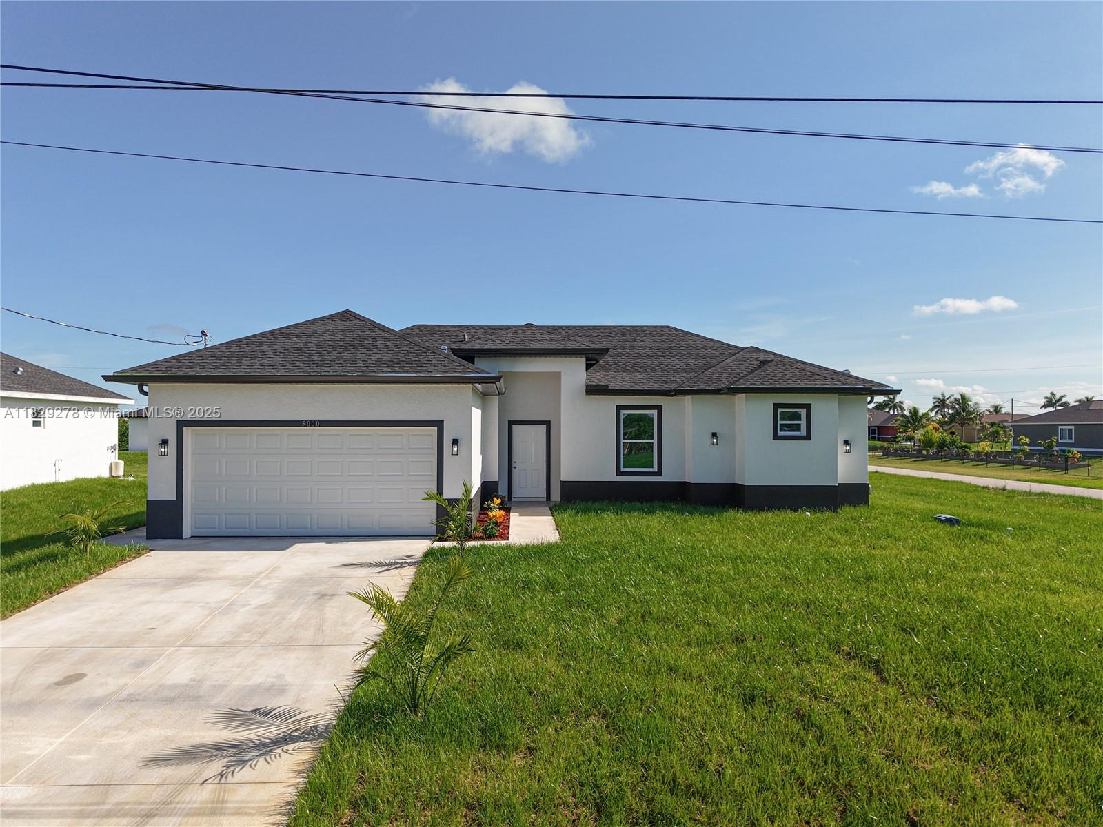 5002 Bygone Street Lehigh Acres, FL 33971 - Photo 4 of 51 a front view of a house with yard and green space