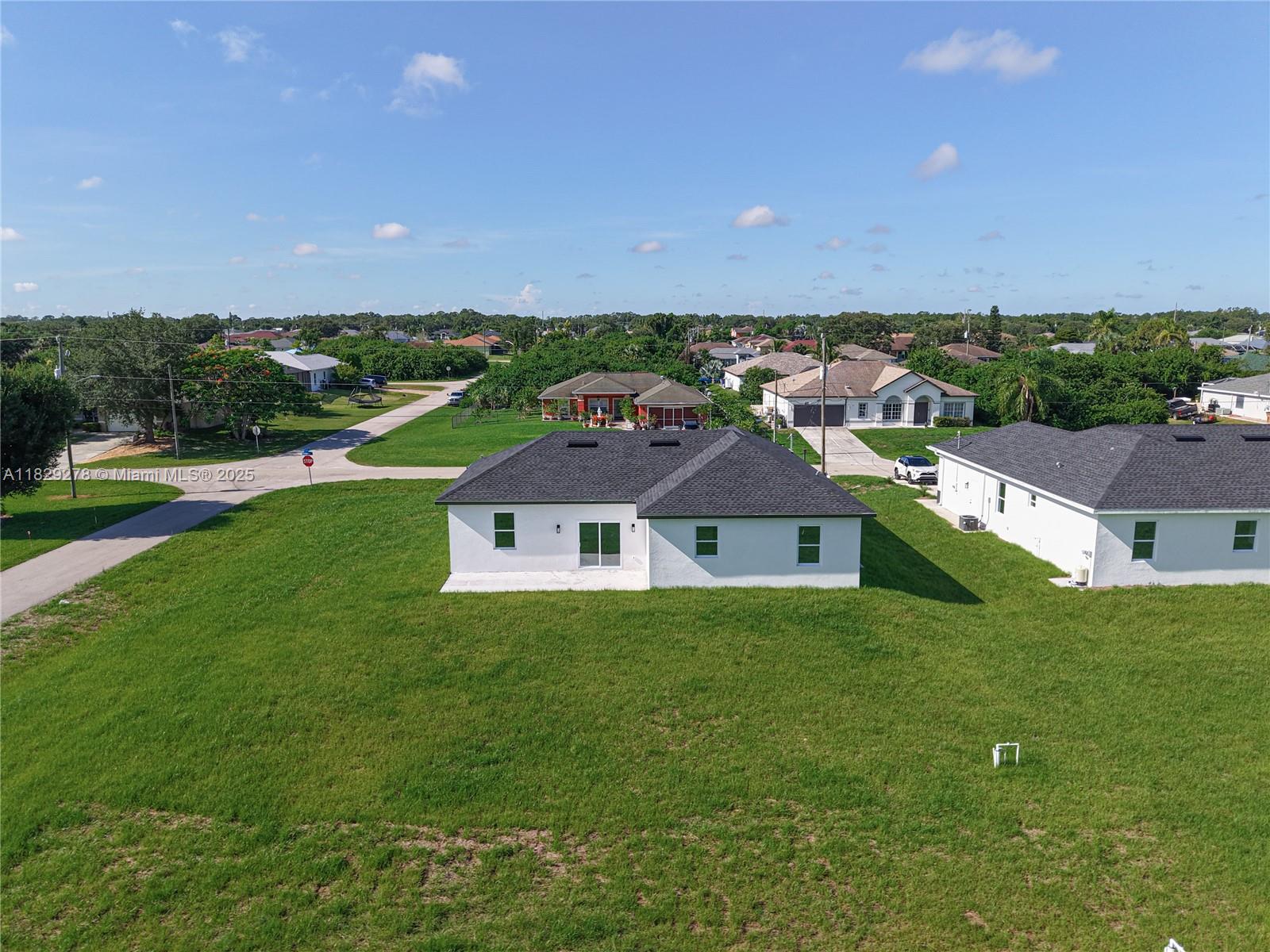 5002 Bygone Street Lehigh Acres, FL 33971 - Photo 49 of 51 an aerial view of a house with a garden