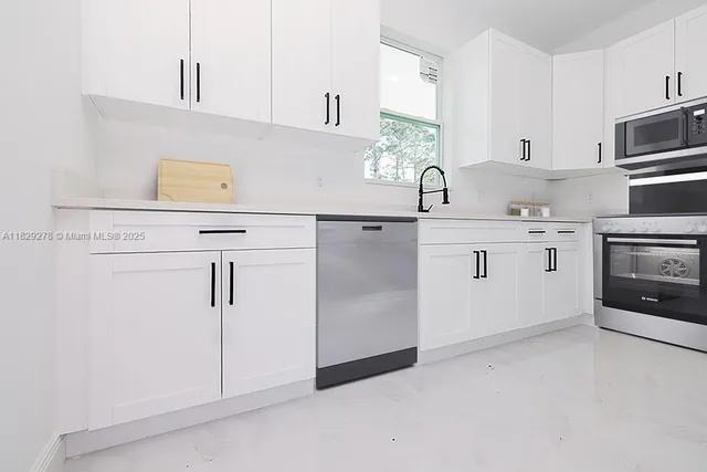 a kitchen with white cabinets and white appliances