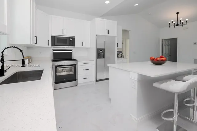 a kitchen with stainless steel appliances a stove refrigerator sink and microwave