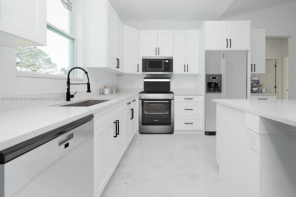 5002 Bygone Street Lehigh Acres, FL 33971 - Photo 8 of 51 a kitchen with white cabinets and white appliances